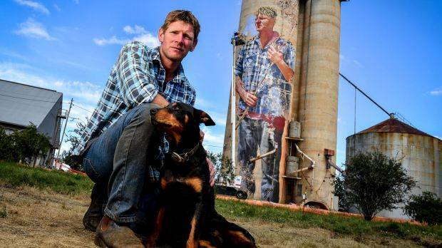 Sheep and wheat farmer Nick Hulland is depicted on the silos at Patchewollock, with his dog Wally. Picture: EDDIE JIM 