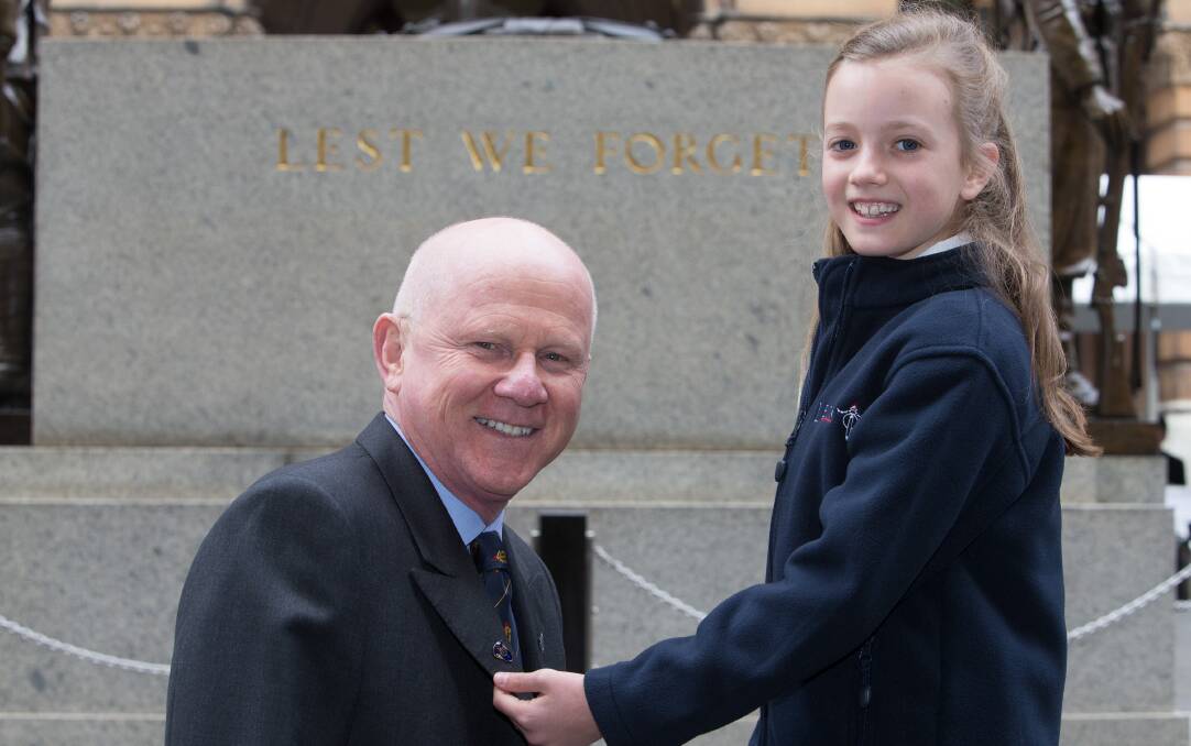 Remembering those left behind: Junior Legatee Lauren Brown pins a Legacy Badge on Sydney Legacy President Paul Lane.
