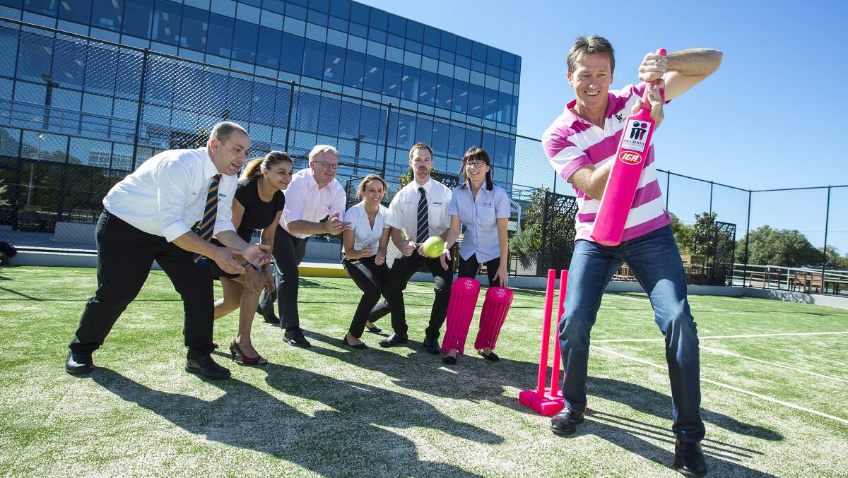 Crunch time: Glenn McGrath gives a crash course in cricket to IGA staff.