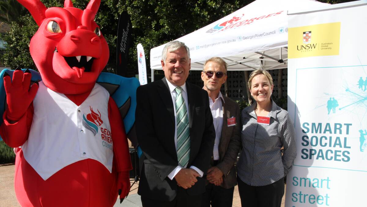 Get smart: Georges River Council mayor Kevin Greene with Dr Christian Tietz and Dr Nancy Marshall of the University of NSW, with Georgie the Dragon in Hurstville's Memorial Square at the launch of the Smart Social Spaces project.