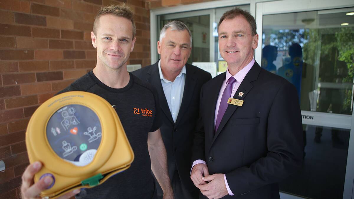 Heart Start: Mark Capelin from Tribe fitness donates a HeartSine defibrillator from Scott Longmuir to De La Salle Caringbah Head Peter Buxton through the Forward Hearts campaign. Picture: John Veage