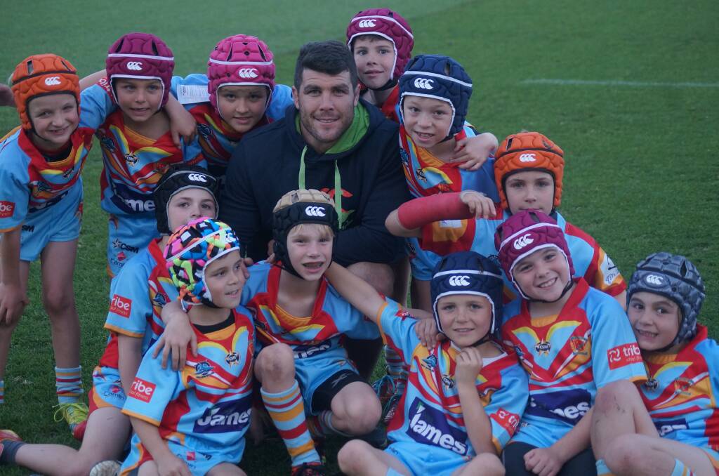 Well protected: Sharks hooker Michael Ennis with the De La Salle Caringbah under-7s after presenting them with their new headgears for the Tommy Bishop Cup this weekend. Picture: Liam Tapper/Cronulla Sharks