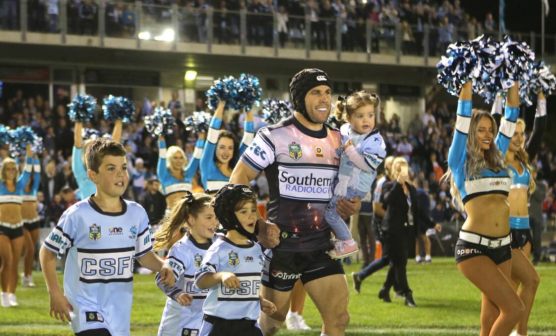Fitting farewell: Cronulla hooker Michael Ennis running out with his children for his last home game with the Sharks last month. Picture: John Veage