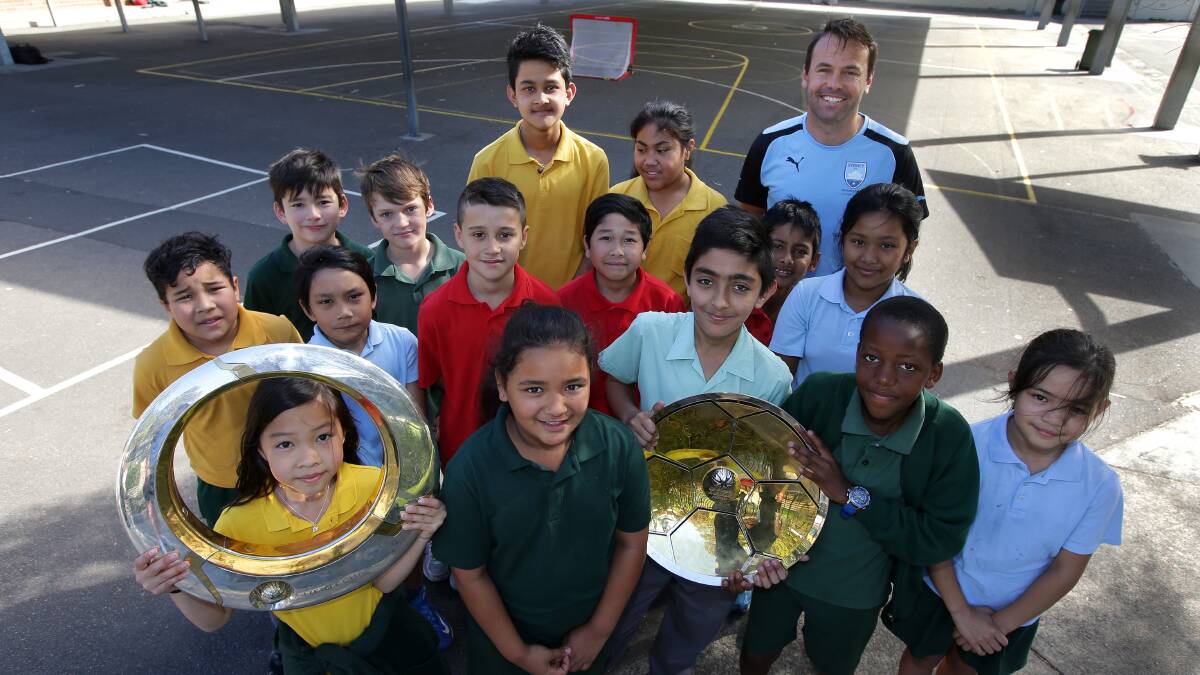 Champion club: Sydney FC community football officer Paul Reid with students from Kogarah Public School and the A-League trophies last week. Picture: John Veage