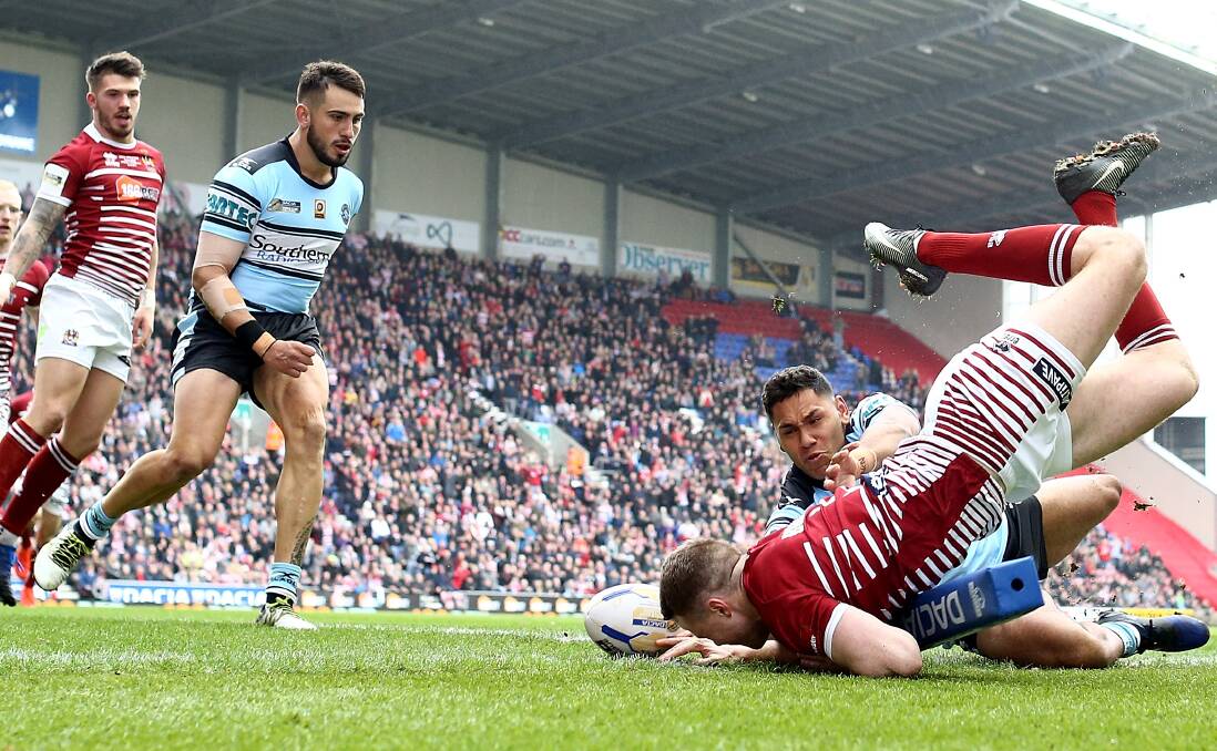 Unstoppable: Wigan winger Joe Burgess scores the opening try, the first of his hat-trick, against Cronulla in the World Club Challenge. Picture: Jan Kruger/Getty Images
