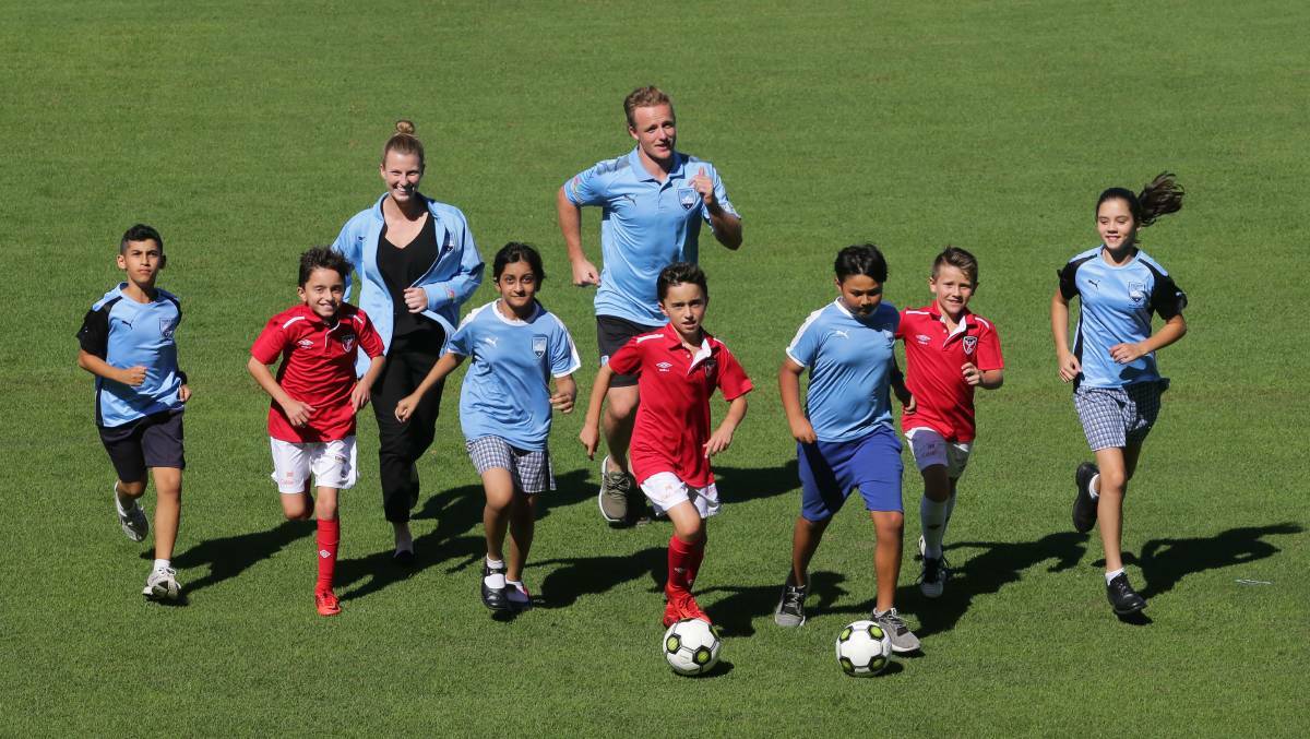 Sydney FC players Ally Green and Rhyan Grant have a kick with some St George juniors. Picture: John Veage