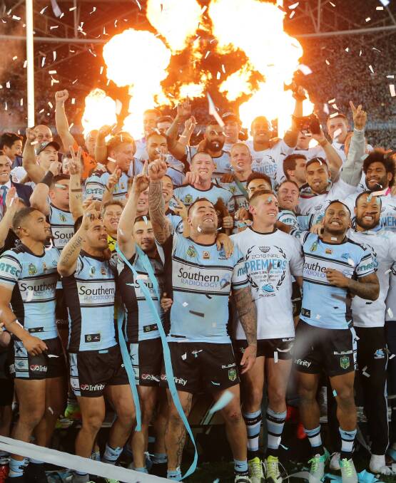 Burning desire: Cronulla Sharks players celebrate their epic grand final victory on stage at ANZ Stadium on Sunday night. Picture: John Veage