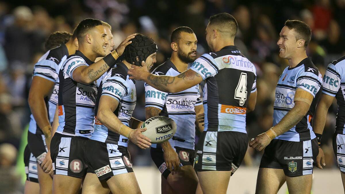 Celebration time: Cronulla players congratulate Michael Ennis on his try. Picture: John Veage