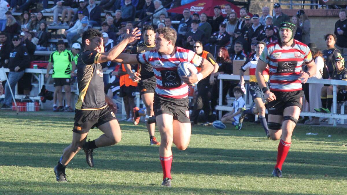Don't argue: Southern Districts winger Alex Gibbon brushes off a Penrith defender in the Rebels' 64-point win on Saturday. Picture: Kim Johnson