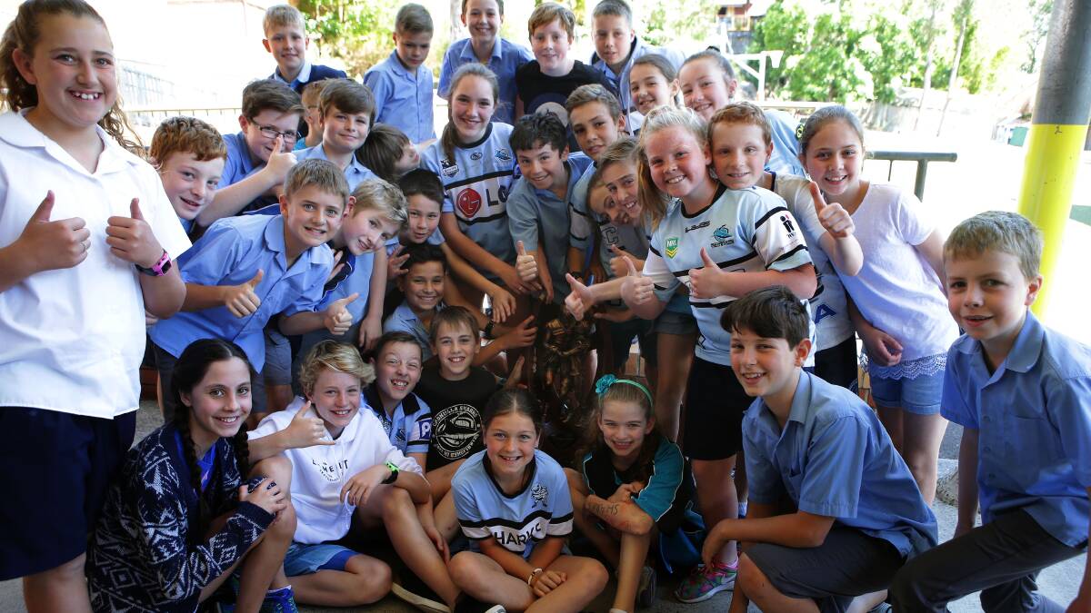 With the prize: Oyster Bay PS students with the NRL premiership trophy on Tuesday. Picture: John Veage