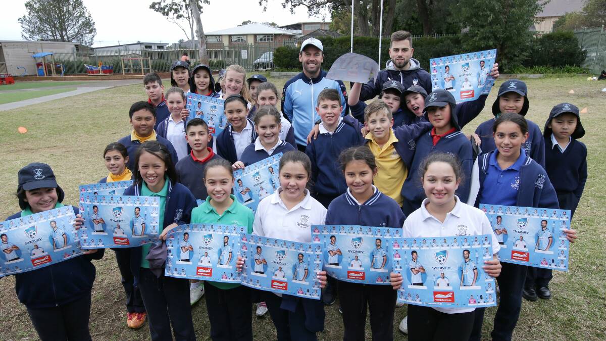 All smiles: Paul Reid and Peter Makrillos from Sydney FC with students from St Mary's Star of the Sea Catholic Primary School, Hurstville on Monday. Picture: John Veage