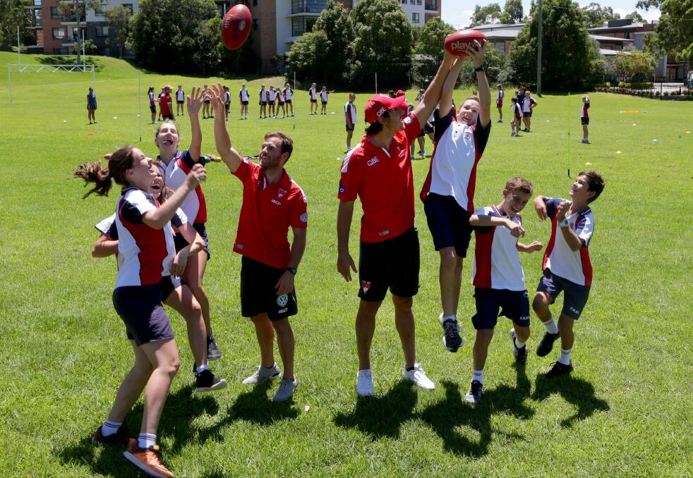 Above the pack: Sydney Swans players Ben McGlynn (left) and Kurt Tippet with students at Port Hacking High School on Monday. Picture: Jane Dyson