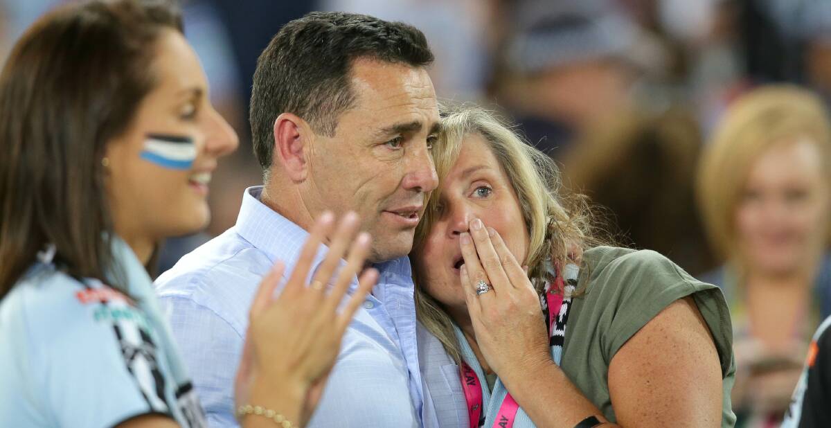 Moment to remember: Cronulla Sharks coach Shane Flanagan with his wife, Kathy, share a moment together on the ground at full-time. Picture: John Veage