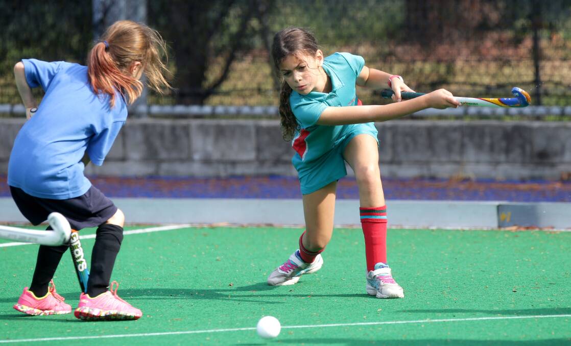 Good pass: Children compete in the Sutherland Hockey Club’s annual school summer competition. Picture: John Veage