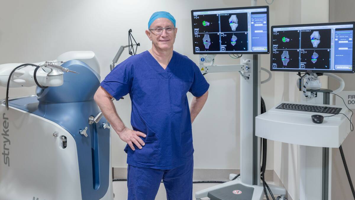 Robotic arm: Orthopaedic surgeon George Kirsh next to the new piece of technology. Picture: Supplied