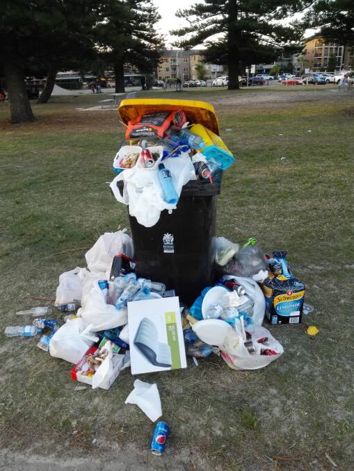Dumped: Piles of rubbish overflow from a yellow recycling bin. Picture: Supplied