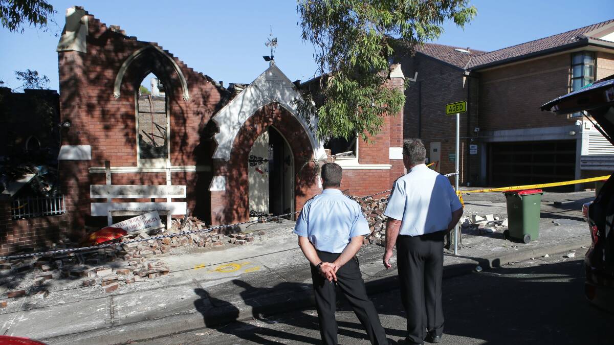Destroyed: Investigators look over a fire which damaged a Rockdale church. Picture: John Veage