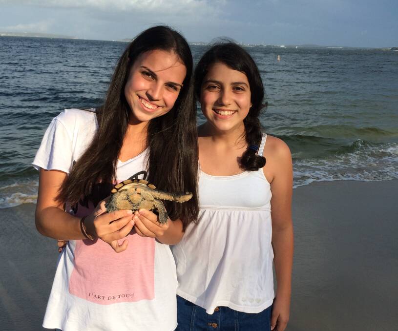 Beach surprise: Elisa and Julia Tsounis with the Eastern Snake-necked turtle. Picture: Andrew Tsounis.