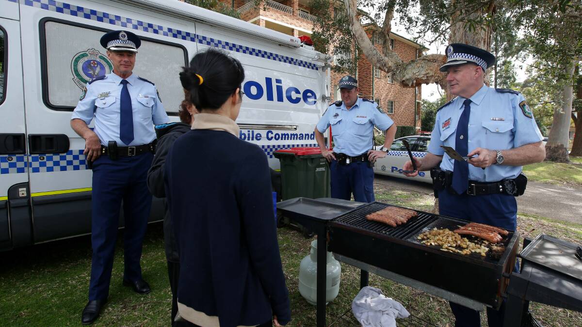 Community event: Miranda police Chief Inspector Mark Magrath cooks up a tasty sausage sandwich for Caringbah residents. Picture: John Veage