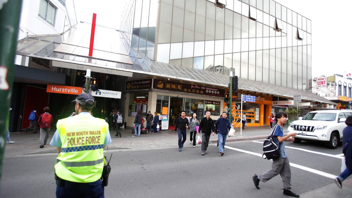Targeted: Pedestrians are closely watched by a police officer outside WestfieldHurstville on Thursday. Picture: Chris Lane