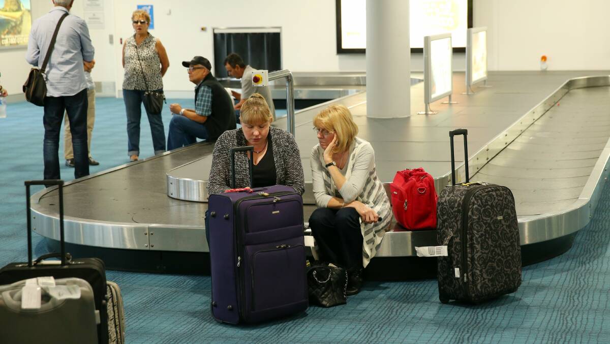 Passengers wait for news in the arrivals hall at Newcastle Airport. Picture: Max Mason-Hubers