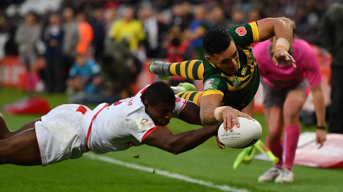 Flying high: Sharks winger Valentine Holmes scores for Australia despite the efforts of England's Jermaine McGilvary. Picture: Mike Hewitt/Getty Images