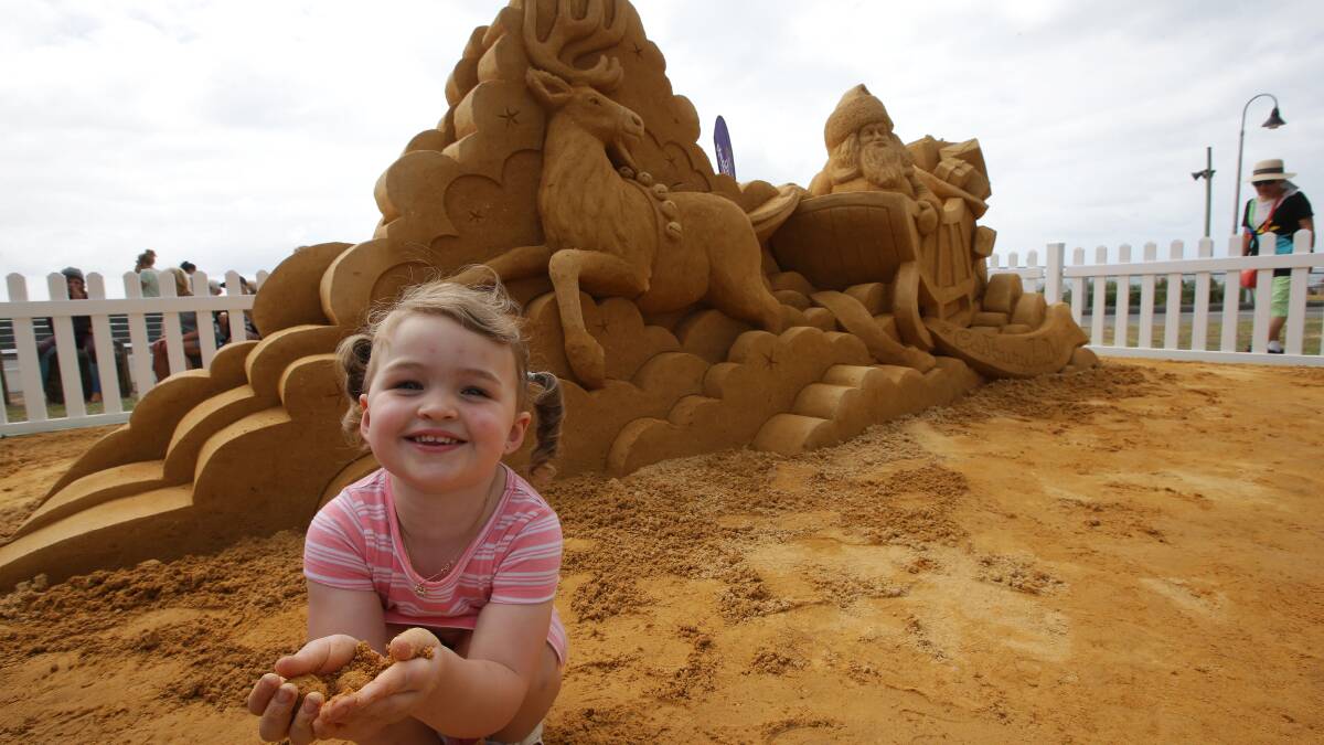 Creation: Ava Pepper, 3, enjoys the sand sculpture. Picture: John Veage