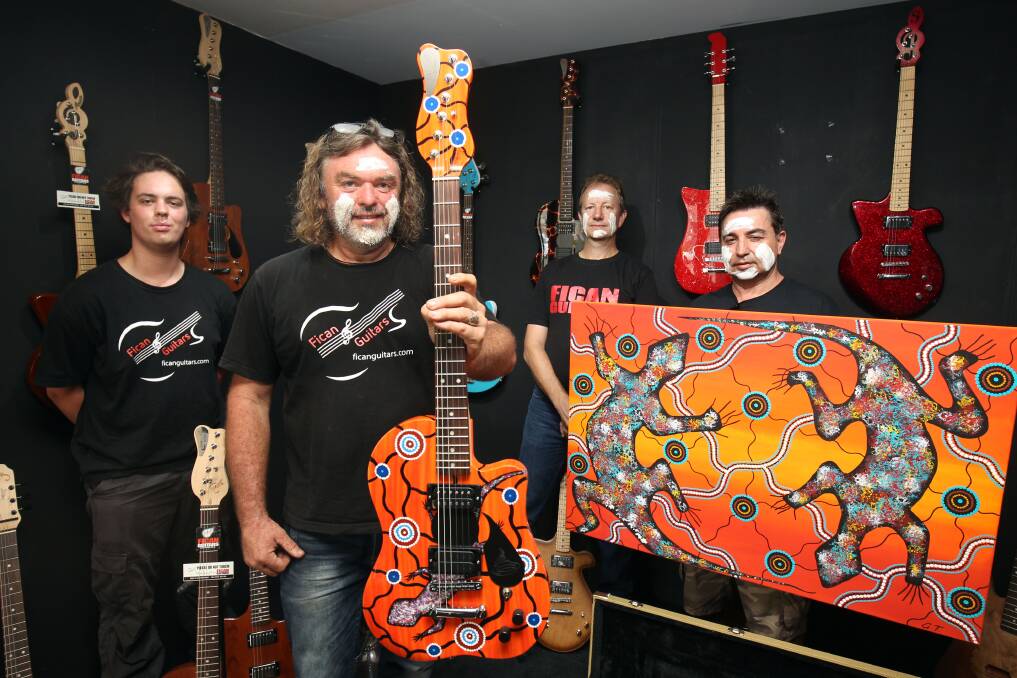 Sound and story: Guitar maker Stuart Monk (centre) is representing Australia in a hand-crated guitar exhibition in Paris in March. Aboriginal artist Graham Toomey (right) has painted the guitar telling his people's story. They are shown with James Lomman and Jeff Cosatto. Picture Chris Lane
