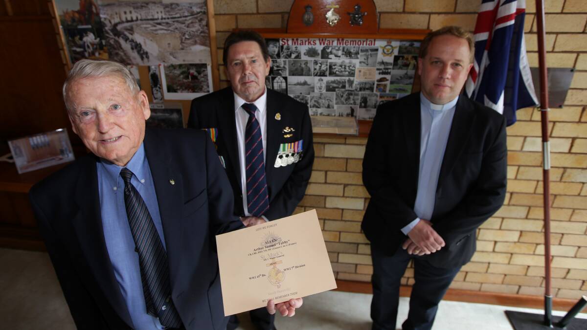 Remembrance: St Mark's Anglican Church has updated their Anzac Book of Remembrance, from left, Wilf Ewens, Greg Jones and Minister Peter Greenwood. Picture: John Veage
