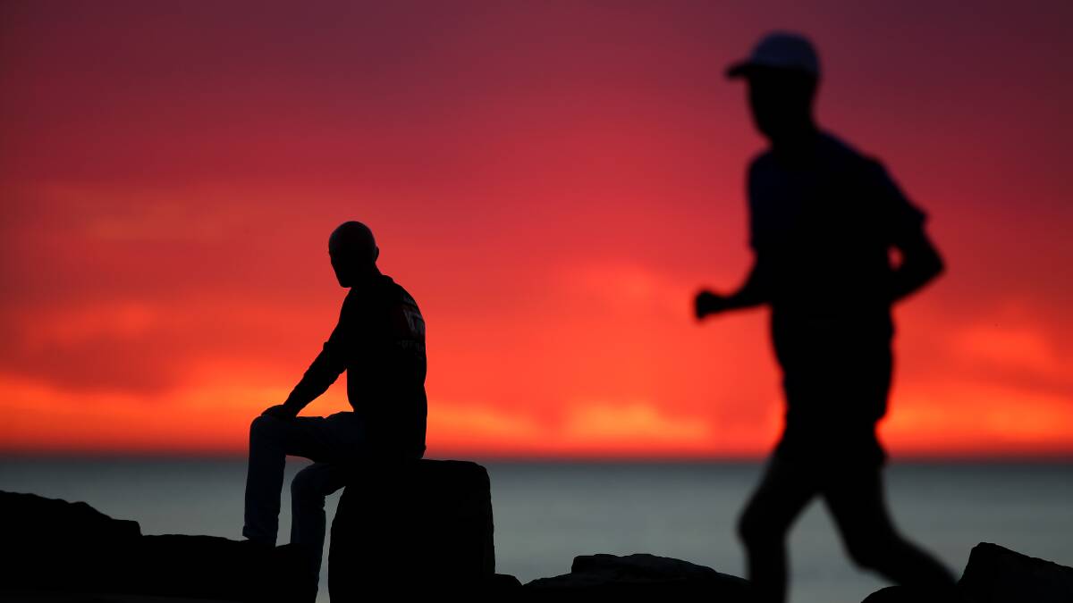 Warm start: People make the most of the early morning rays at North Cronulla beach. Pictures: John Veage