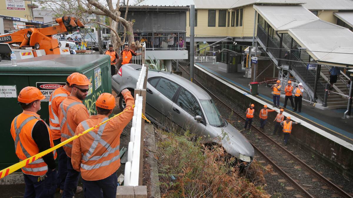 A crane has been called in to remove this car at Penshurst station after it ploughed through a fence and ended up on the tracks.