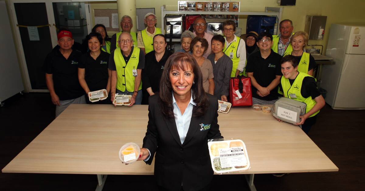 Making a difference: Nahed Soliman with volunteers in the kitchen of St George Meals on Wheels in the basement of Peakhurst Bowling Club. Picture: Chris Lane