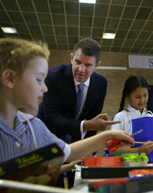 Eager to learn: Mike Baird picks up some painting tips from pupils at Sutherland Shire Christian School. Picture: John Veage