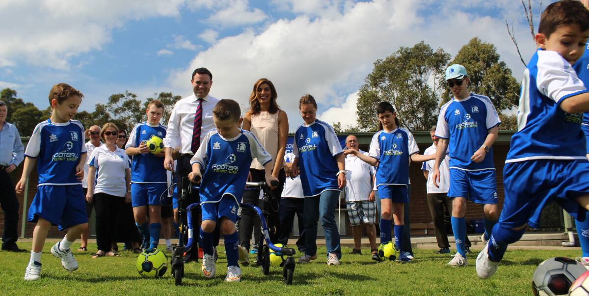 Community the winner: Titans FC players and parents with Stuart Ayres and Eleni Petinos at the announcement the club will move next season to a new home ground at Coachwood Reserve, Alfords Point.