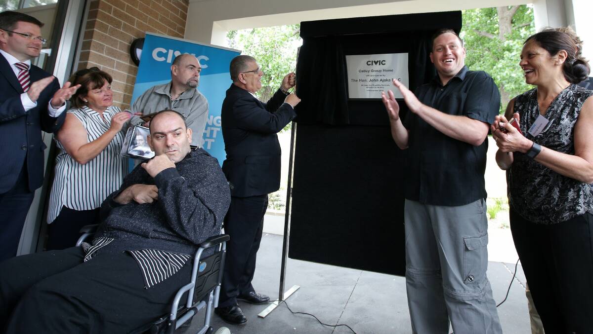 In the community: John Ajaka unveils a plaque for the new, five-bedroom group home, which blends in among other homes in Ada Street. Picture: John Veage
