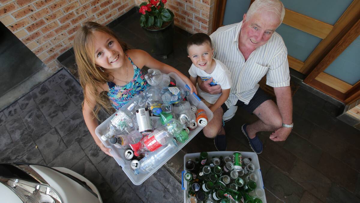 Greg Bleazard and grandchildren Marley, 8, and Carter, 5, with some of the cans and bottles they collected. Picture: John Veage