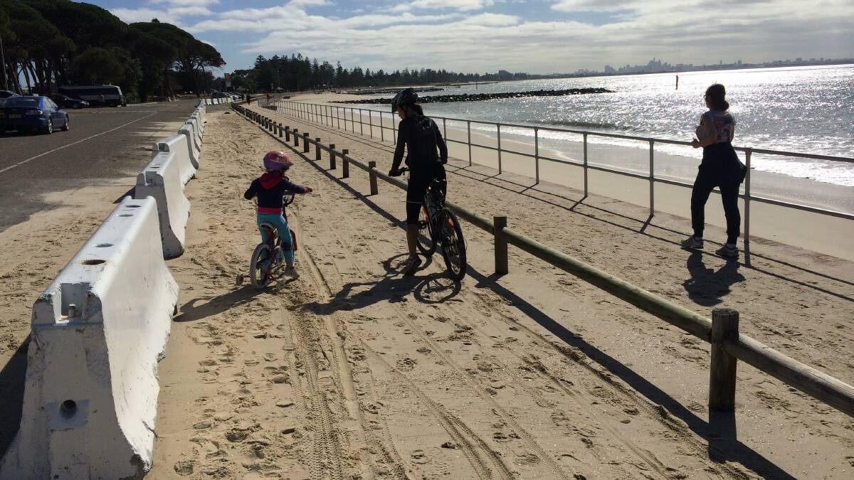 The cycleway on Saturday after big seas deposited tonnes of sand .