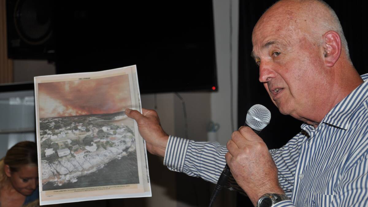 Resident Phil Targett at a community meeting with a photo of a previous fire which threatened Heathcote East.