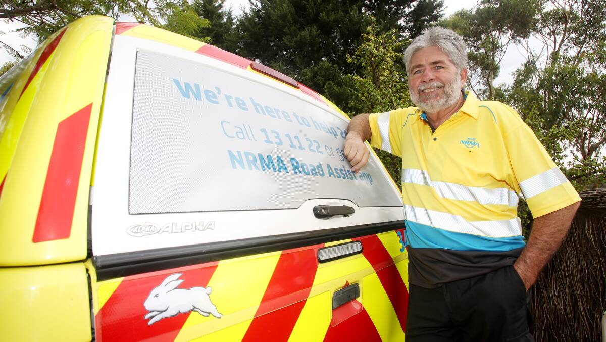 NRMA patrolman Barry Bennett with his van, which has a South Sydney Rabbitohs sticker on the back. Picture: Chris Lane