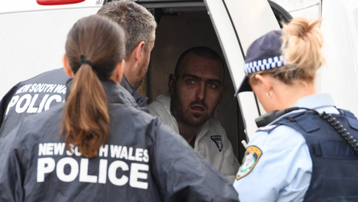 Police speak to a man who escaped from the house on Paringa Place in Bangor. Picture: Peter Rae