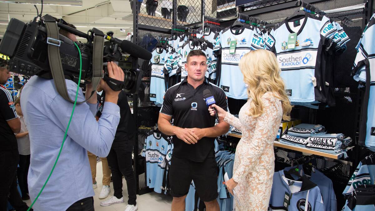 All your Cronulla gear available: Sharks player Chris Heighington is interviewed at the launch by Erin Moylan.