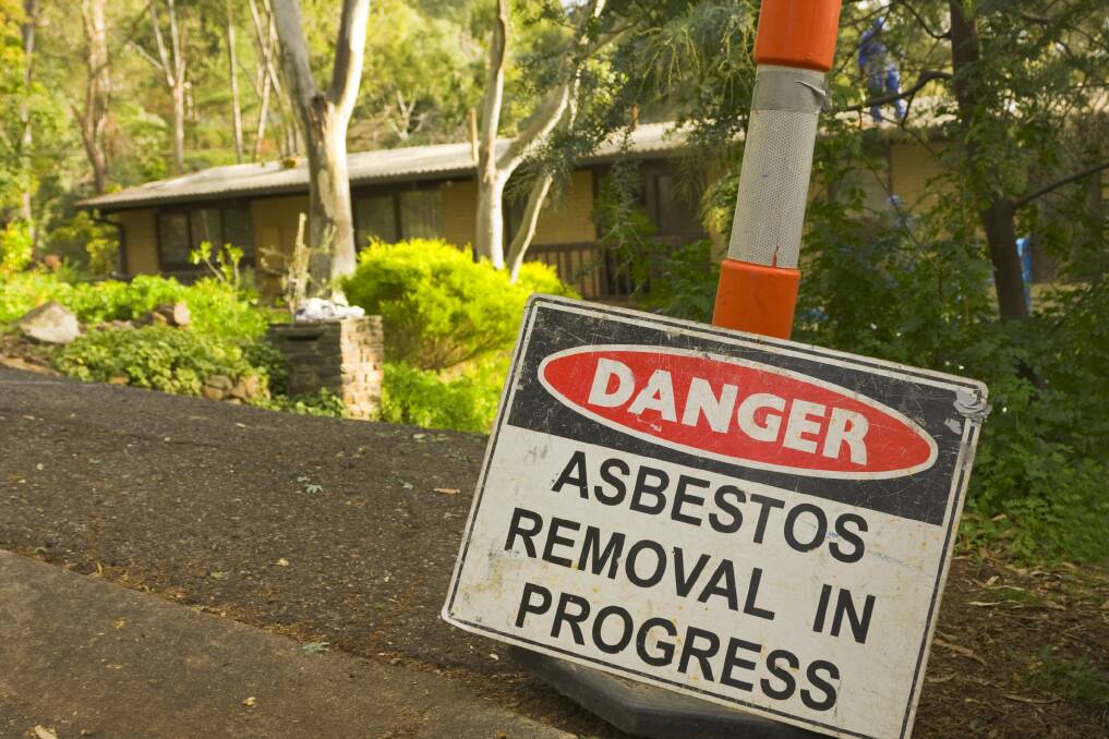 Asbestos warning sign in front of a suburban home 