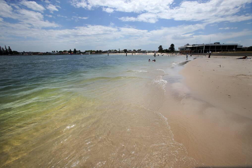 Hidden risk: Families enjoy the beach just days after a girl, 8, was pulled unconscious from the water. While the water appears shallow, it drops off quickly to deep water as can be seen in the change of colour. Picture: Jane Dyson