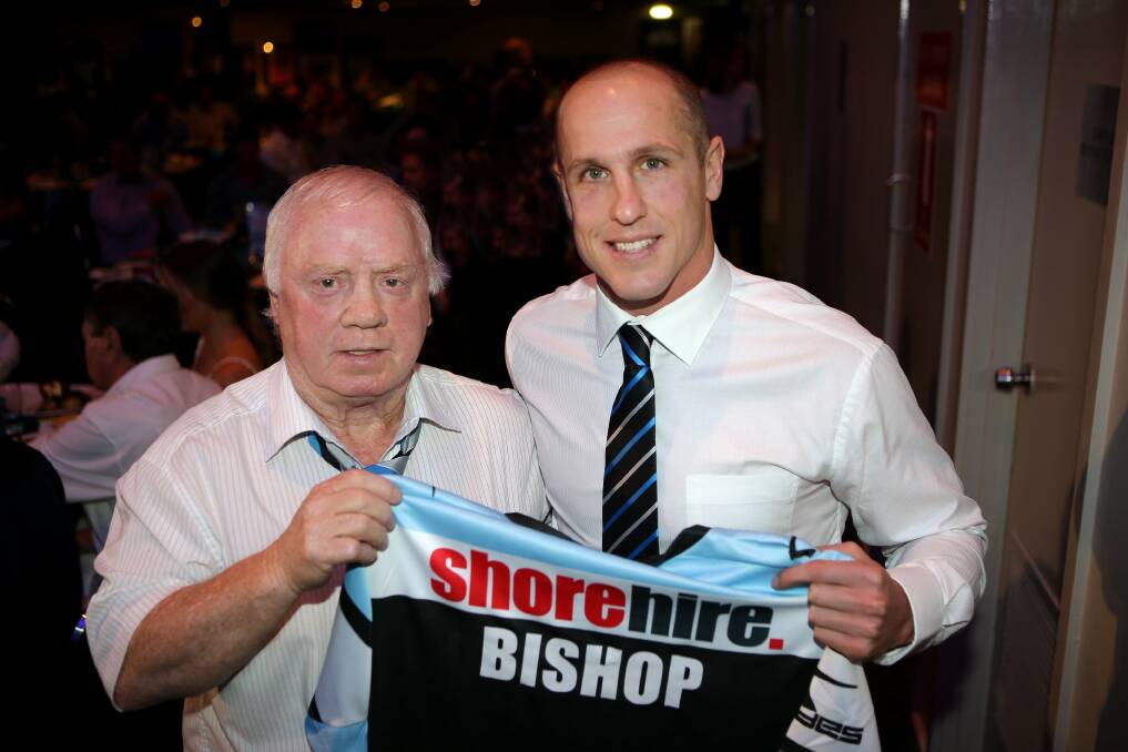 Two halves: Former Sharks captain and champion scrum-half Tommy Bishop receives a Cronulla jersey with his own name on it from Sharks No. 7 Jeff Robson at the recent grand final luncheon. Picture:  John Veage