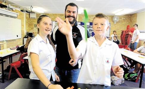 New approach: Teacher Peter Reeve shows the science behind a paper plane to students Alex Hoolihan and Callum Weatherhall. Picture: Chris Lane