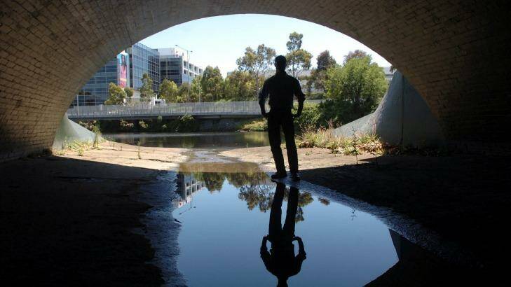 A person stands in one of the main sewerage outlets that flow into the Yarra River. Photo: Joe Castro
