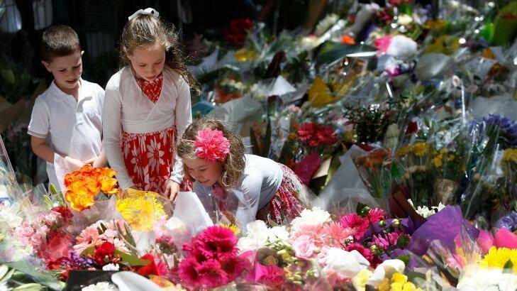 Three children leave a tribute to the victims of the siege in Martin Place.  Photo: Fairfax Media