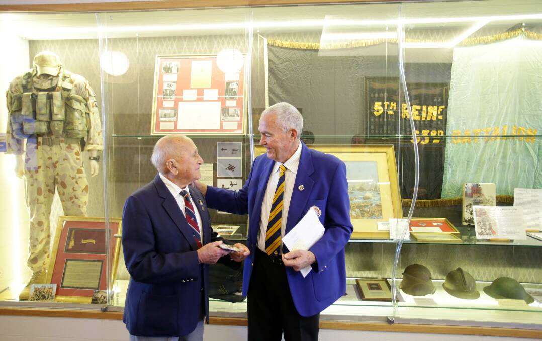 Honour: Eric Barton receives his French Legion of Honour, now mounted with his other medals, from Cronulla RSL Memorial Club president Ian Bourke. The club paid to have the Legion of Honour mounted. Picture: Chris Lane
