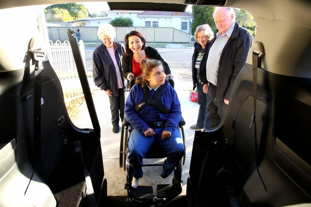 Have wheels, will travel: Mum Naovy Nappa helps Gabby Nappa inside the converted Toyota Tarago while Hurstville Rotarians Dorothy Dixon, Jan Gartrell and Bernie Dolan look on. Picture: Jane Dyson