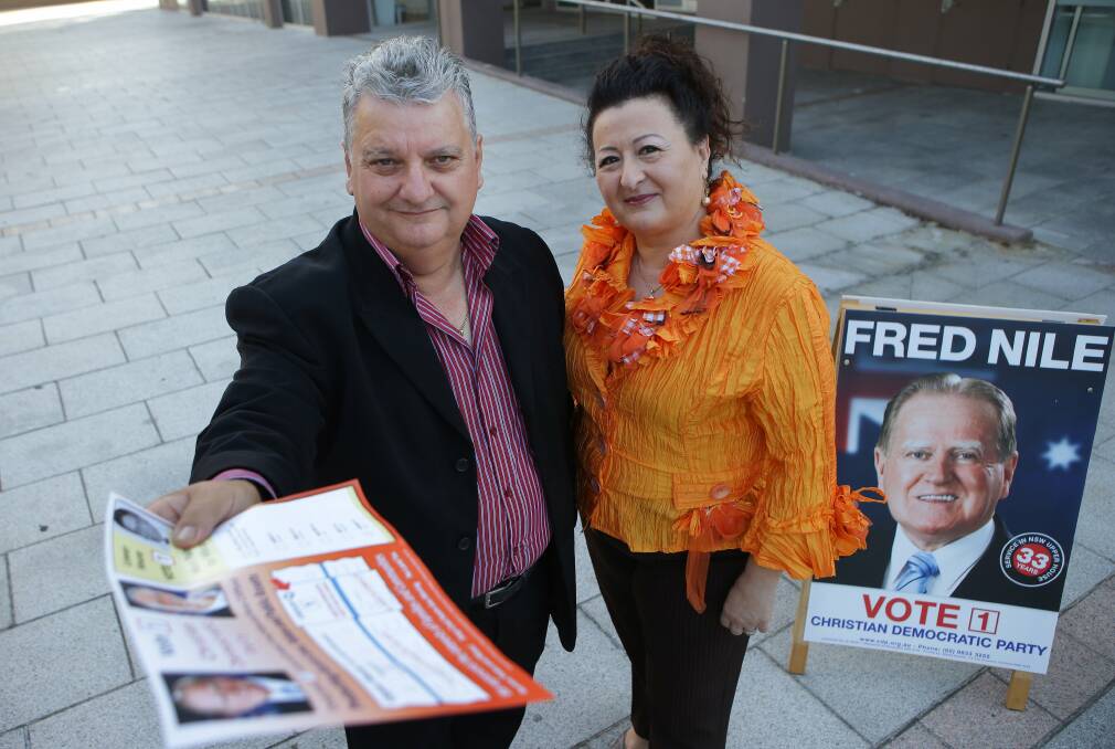 Committed candidates: Ula and Mark Falanga, who are standing for the Christian Democratic Party in Heathcote and Miranda, hand out how-to-vote cards at a pre-poll centre. Picture: John Veage